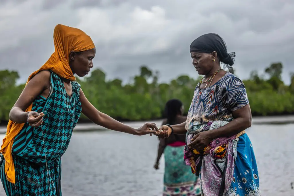 Women conversing on the edge of the water