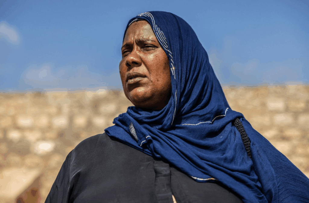 A woman wearing a head scarf looking into the distance