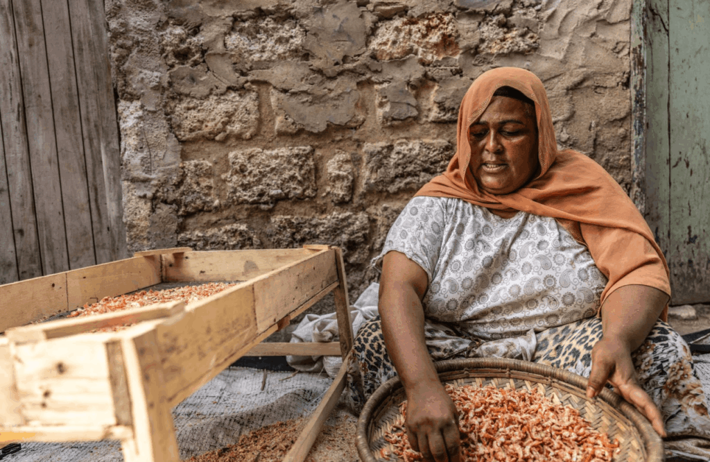 A women sorting through her catch of shrimp
