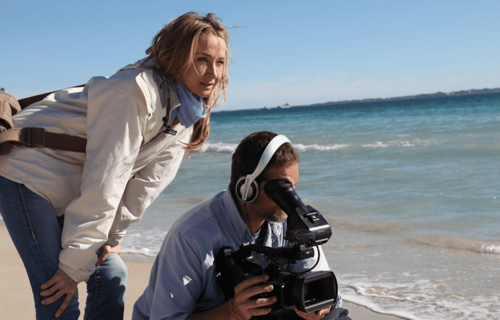 Alexandra filming on a beach